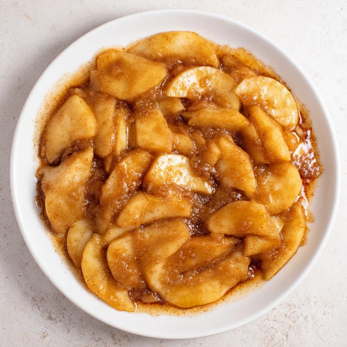 Golden-brown baked apple slices glistening with a cinnamon-brown sugar glaze – a cozy treat.
