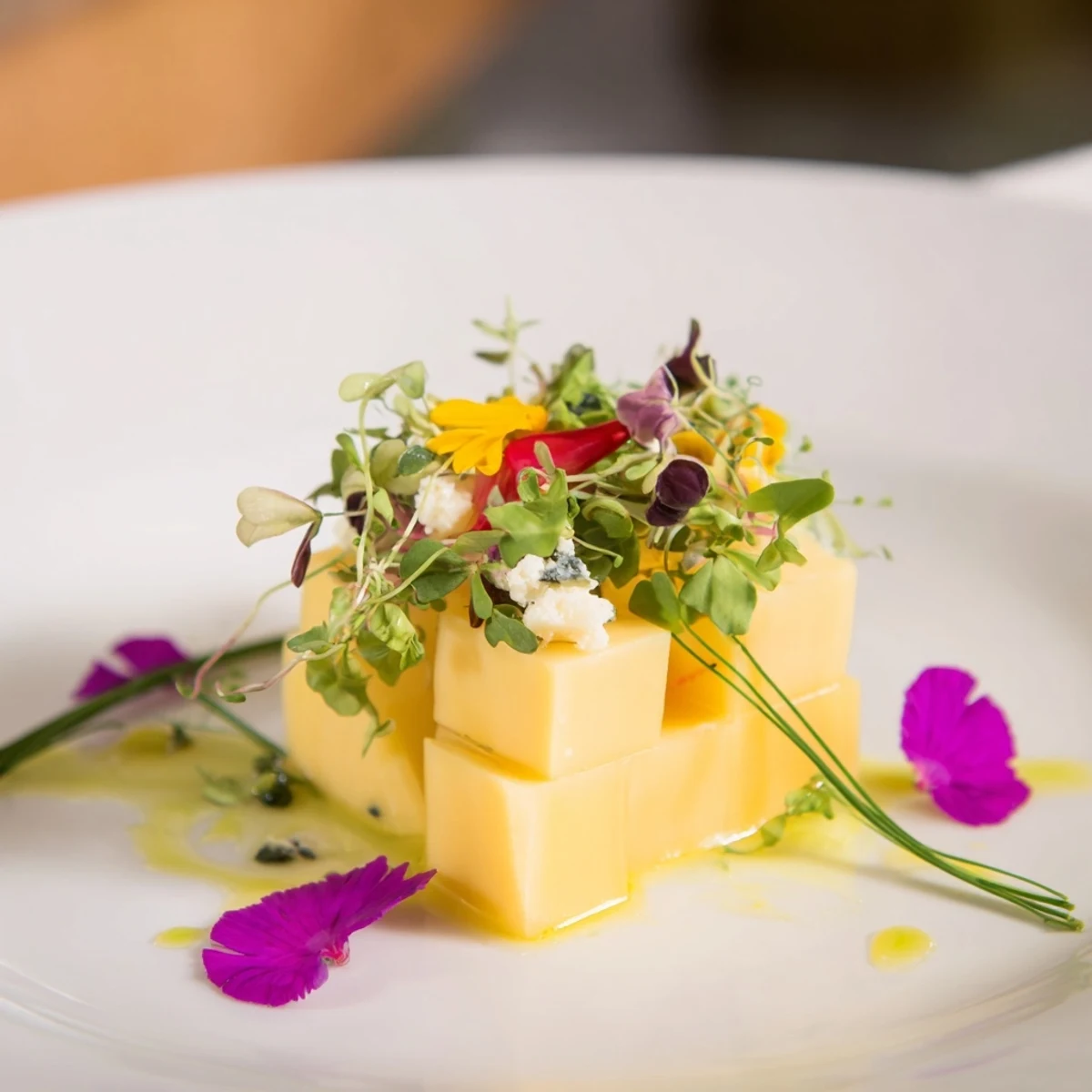 Fresh, layered "The Secret Garden" appetizer with cheese, greens, and blooms, perfect for any occasion.