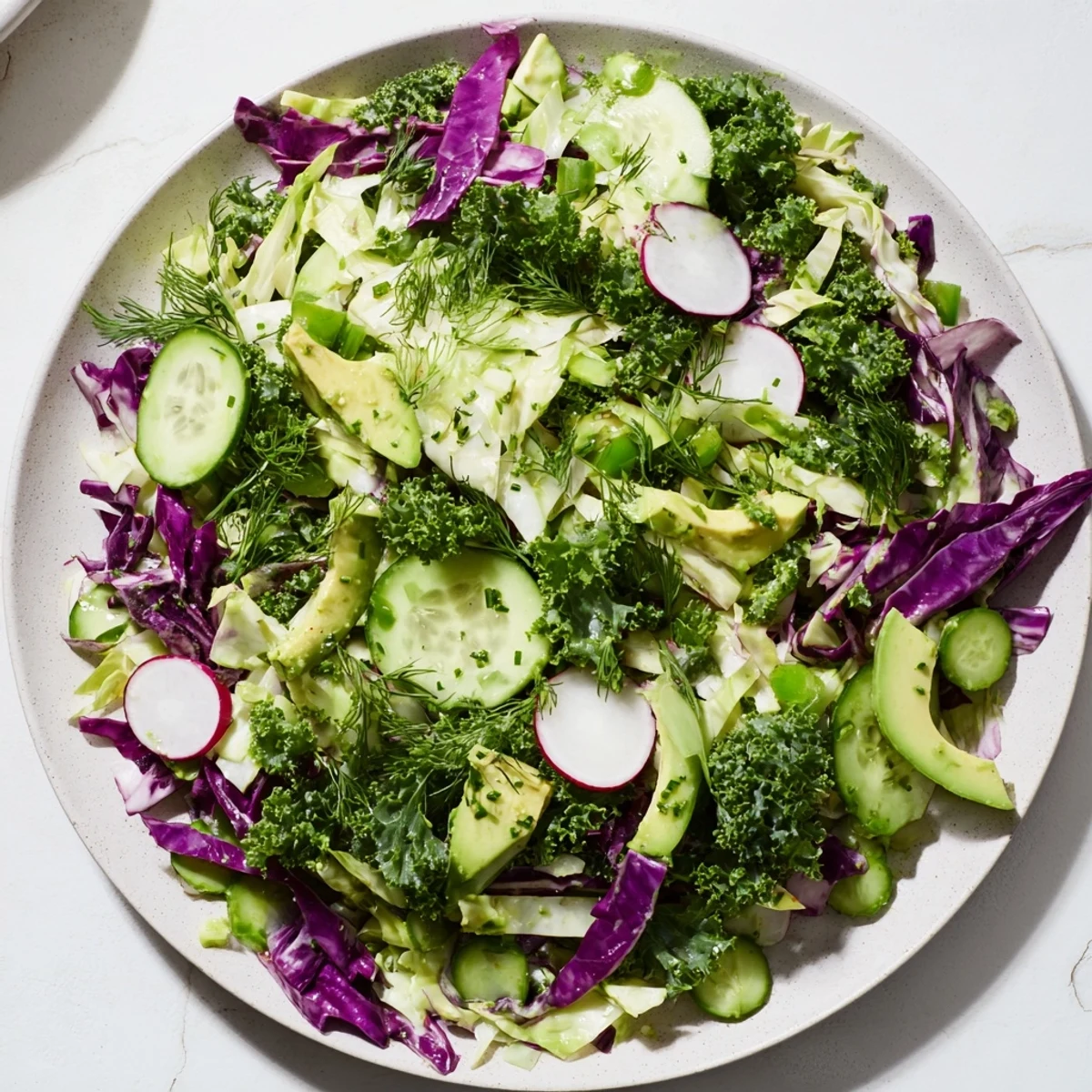 Freshly tossed Green Goddess Detox Cabbage Salad, bursting with vibrant green and purple vegetables for a healthy lunch.
