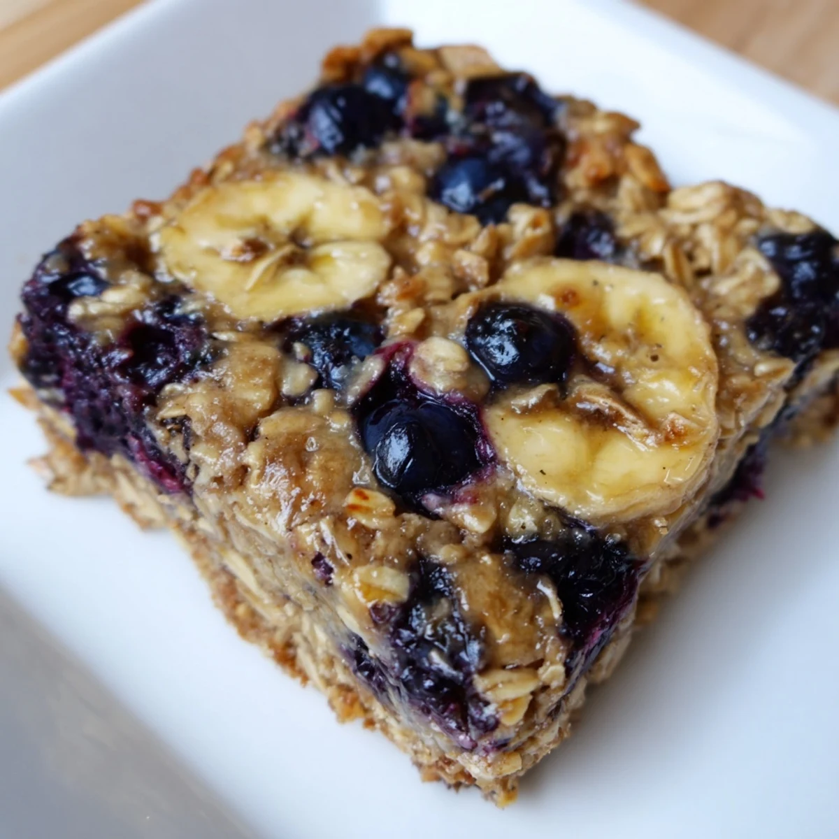 Freshly baked Blueberry Banana Oatmeal Protein Bars, filled with oats, ripe bananas, and bursting with flavor.