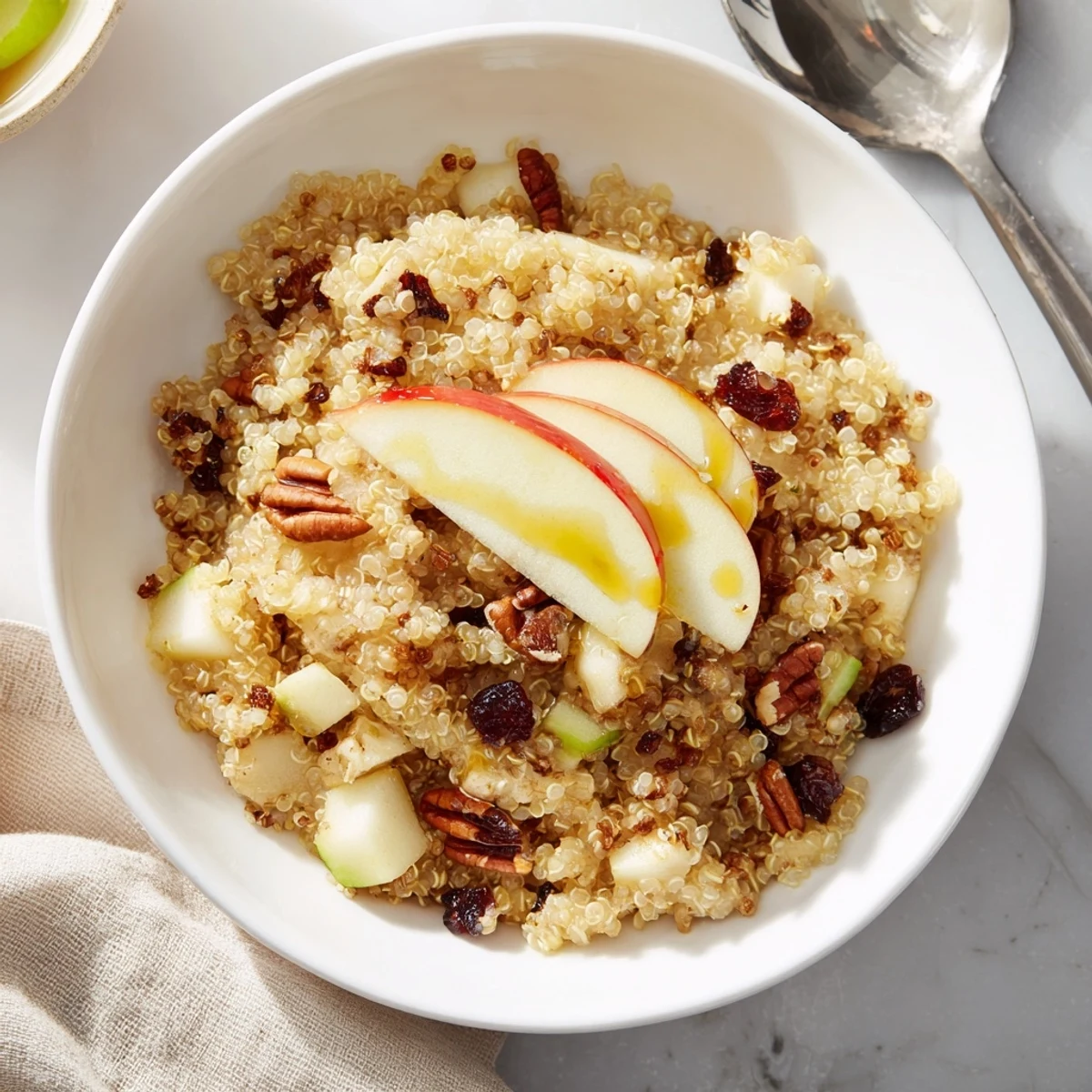 Steaming Apple Cinnamon Quinoa Bowl, with sweet apples, cinnamon, and crunchy walnuts, ready to eat.