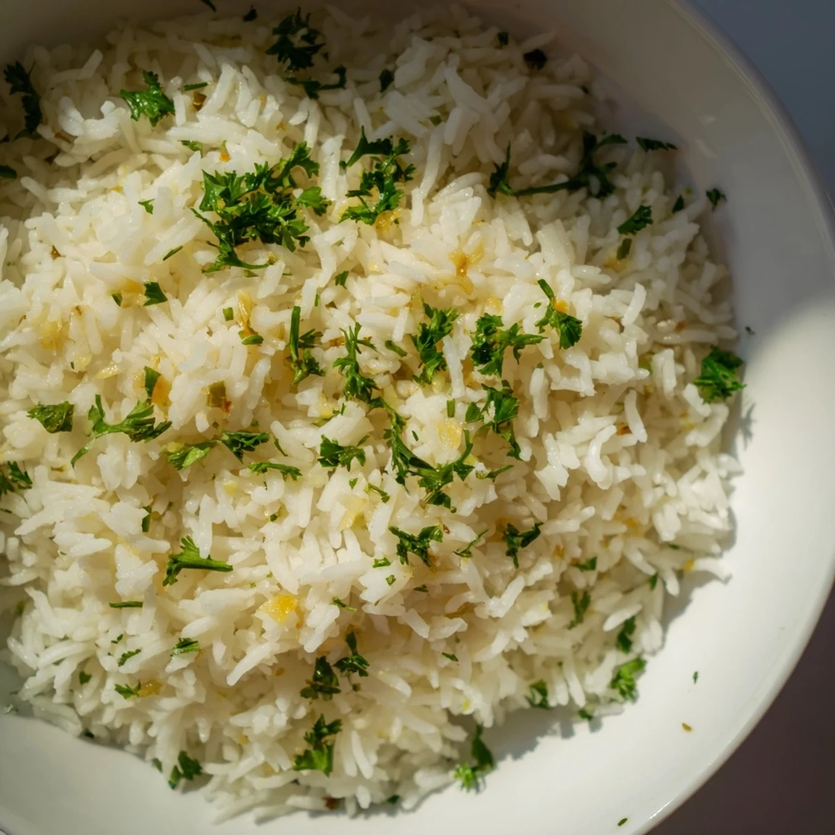 Steaming bowl of garlic butter rice: savory side dish cooked to tender perfection, simple and flavorful.
