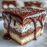 Elegant vanilla graduation cake with silky white chocolate buttercream, dramatic white chocolate drip, and shimmering gold balloon decorations for a memorable milestone celebration.