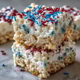 Vibrant red, white, and blue Rice Krispies treats stacked in festive layers, perfect for Independence Day celebrations.