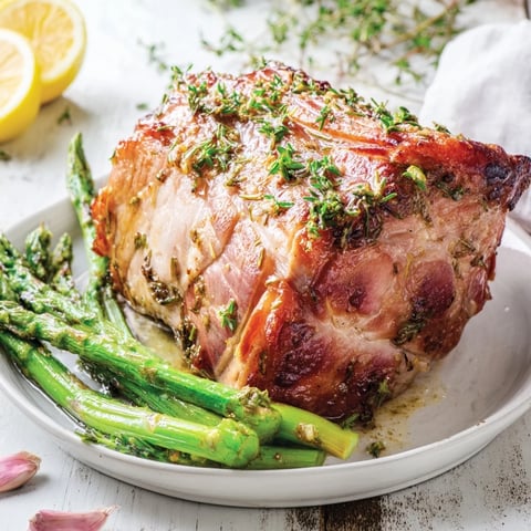 Golden brown One-Pan Lemon Herb Pork Chops with asparagus, glistening from the lemon-herb marinade, ready to eat.