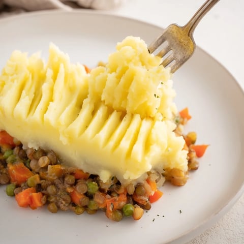 Steaming Hearty Lentil Shepherds Pie with fluffy mashed potato topping, a fantastic vegetarian meal.