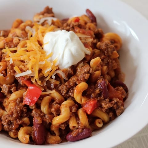 Steaming bowl of one-pot chili mac with melted cheese and ready to serve.