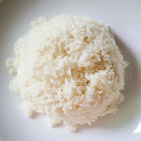 Steaming Coconut Jasmine Rice in a white bowl, offering a creamy, aromatic side dish easily made.