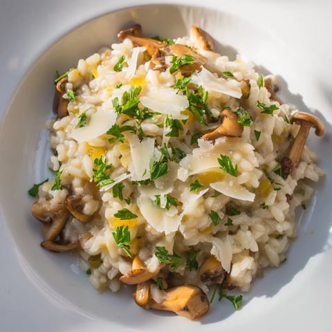 Steaming bowl of risotto with mushrooms, garnished with Parmesan; a creamy, Italian delight.