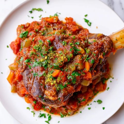 Tender, braised Osso Buco with melting veal shanks, served atop creamy risotto garnished with Gremolata.