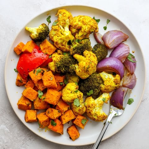 Golden Anti-Inflammatory Turmeric Roasted Vegetables piled high on a serving platter, showcasing tender cauliflower and broccoli with a vibrant, aromatic spice coating.  
