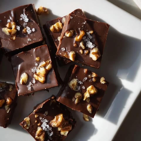Rich, dark chocolate forms the base of this smooth, homemade Easy Chocolate Fudge treat with optional nuts.