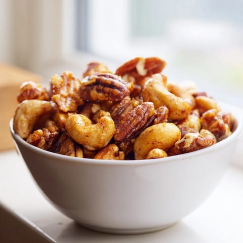 A close-up view of glazed Spiced Nuts Mix clusters for snacking on a cheese board.