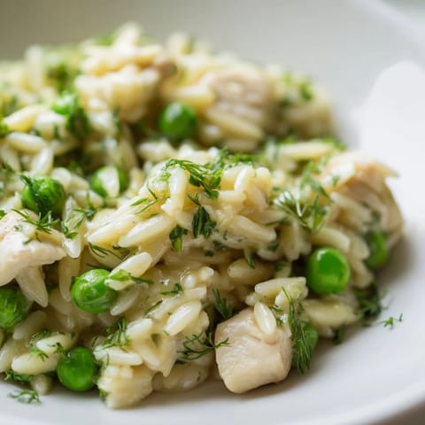 Bright lemon herb chicken orzo skillet served steaming from the pan, with fluffy orzo, peas, and tender chicken pieces perfect for a light dinner.