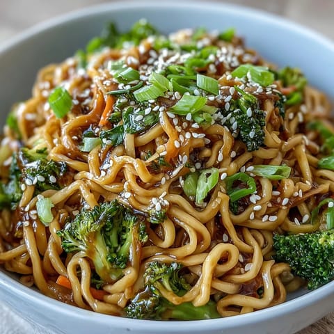 Steaming bowl of Asian Teriyaki Noodle Bowl with broccoli and toasted sesame seeds.