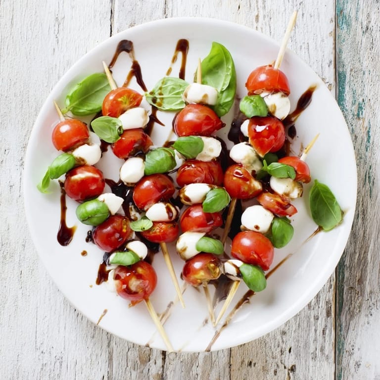 Bright red cherry tomatoes and creamy mozzarella shine on Fresh Caprese Salad Skewers ready to serve.