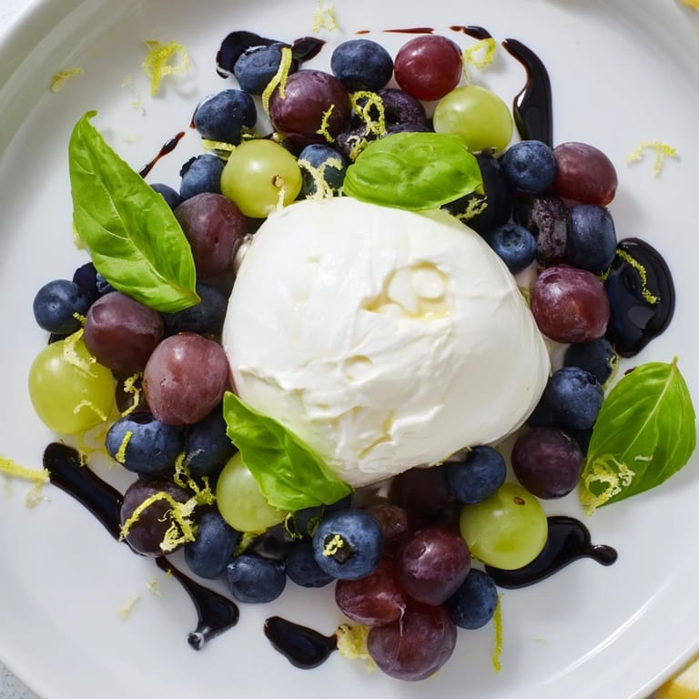 A visually stunning Moonlit Lagoon salad offers juicy grapes and blueberries with a delicate burrata center and basil.
