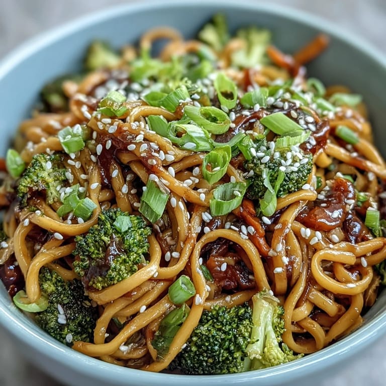 Garnished Asian Teriyaki Noodle Bowl served with julienned carrots and vibrant green onions.