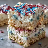 Vibrant red, white, and blue Rice Krispies treats stacked in festive layers, perfect for Independence Day celebrations.